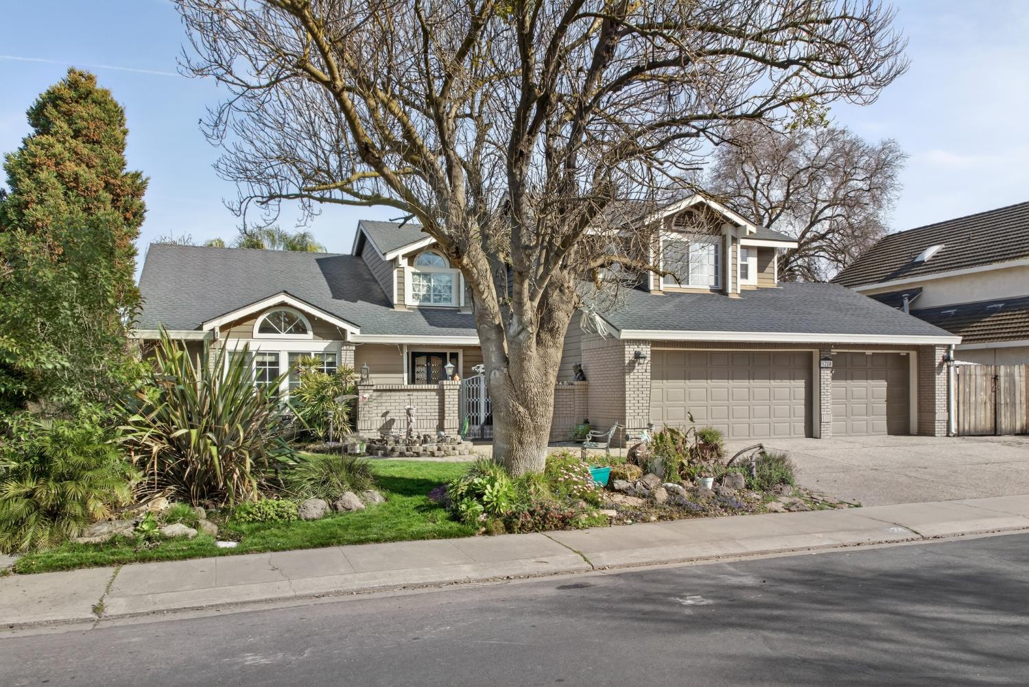 1224 Glenbrook Way Modesto, CA 95355 - Photo 3 of 49 front view of a house with a garden