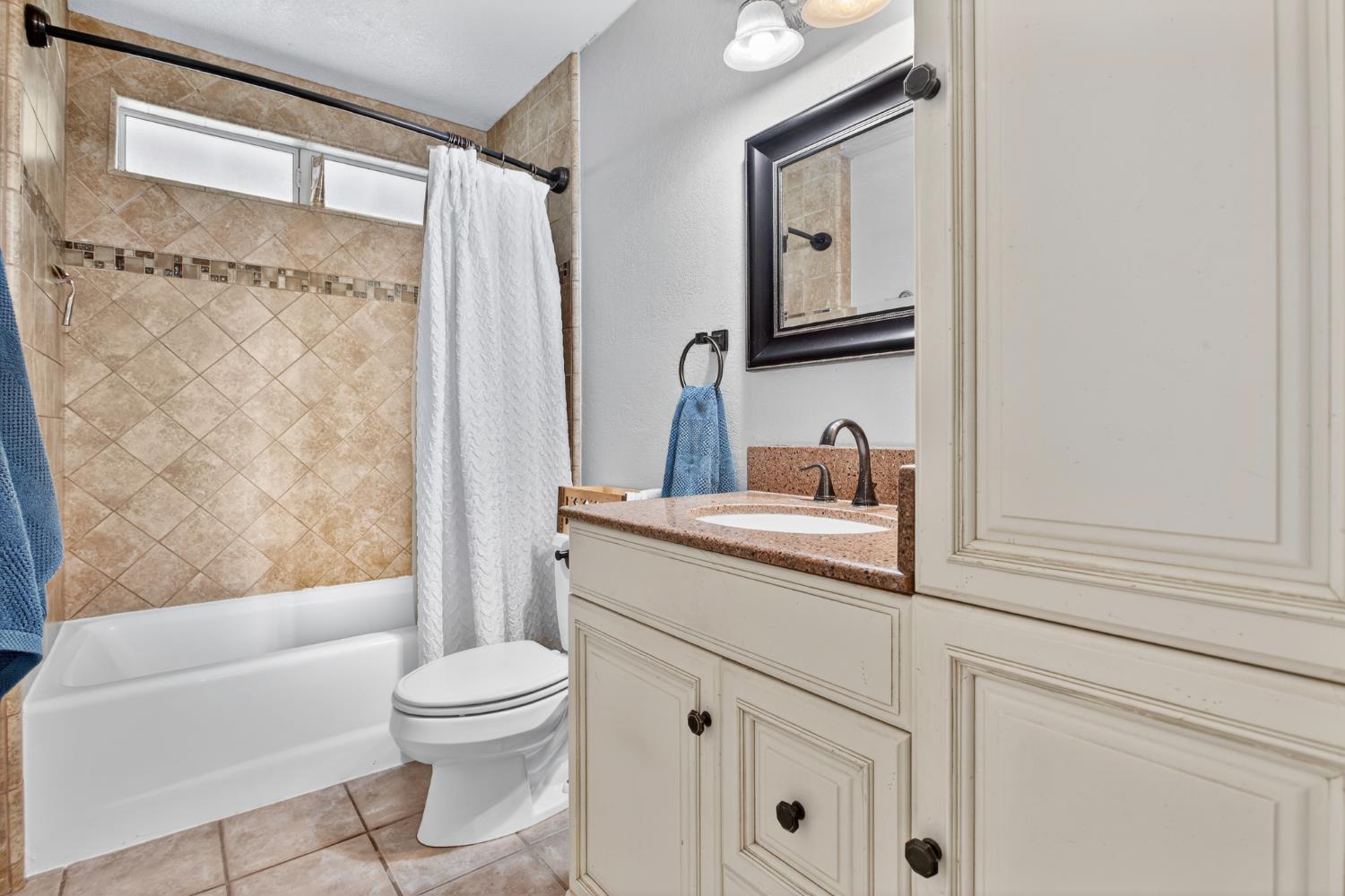 1224 Glenbrook Way Modesto, CA 95355 - Photo 36 of 49 a bathroom with a granite countertop sink toilet a mirror and shower