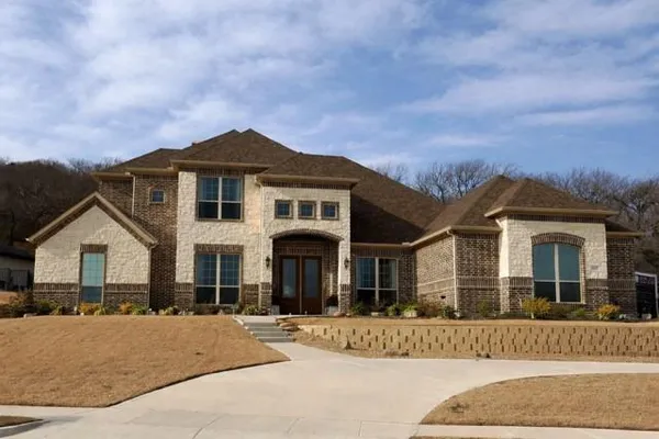 a front view of a house with a garden and yard
