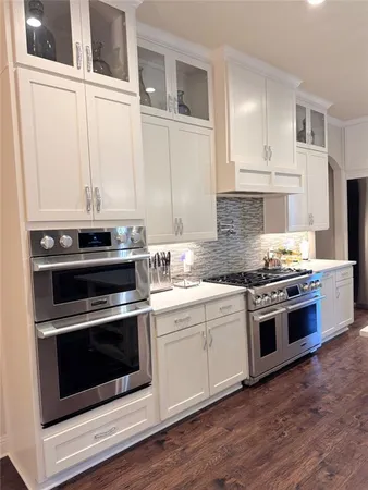 a kitchen with granite countertop white cabinets and stainless steel appliances
