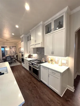 a kitchen with stainless steel appliances granite countertop a stove a sink and a refrigerator