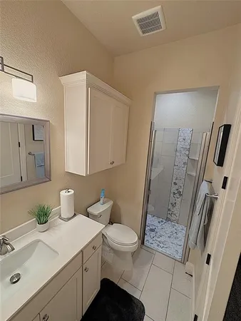 a bathroom with a sink a toilet and shower a mirror