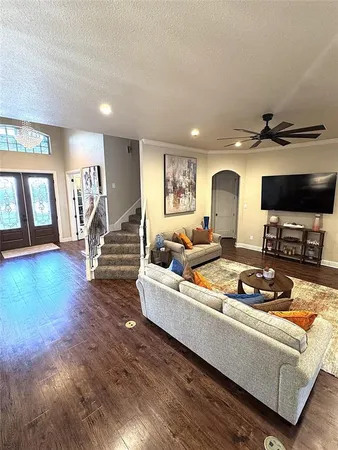 a living room with furniture and a wooden floor
