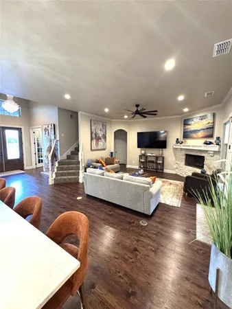 a living room with furniture kitchen view and a large window