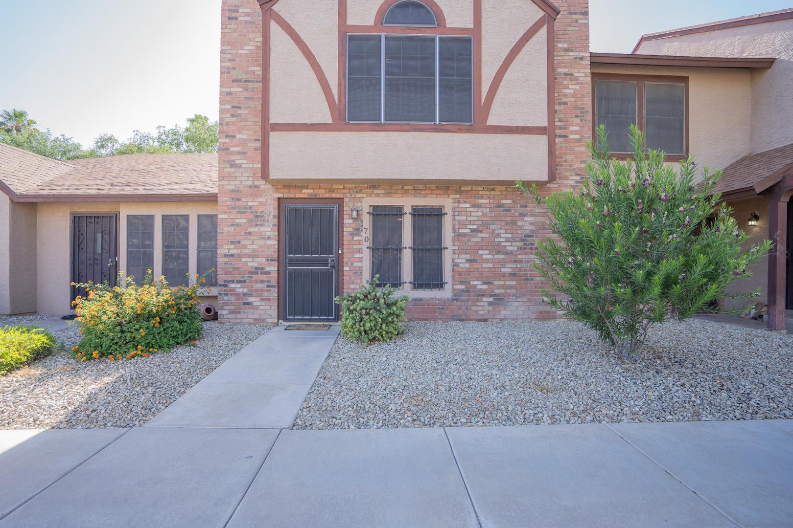 8111 West Wacker Road, Unit 70 Peoria, AZ 85381 - Photo 3 of 38 front view of a brick house with a yard