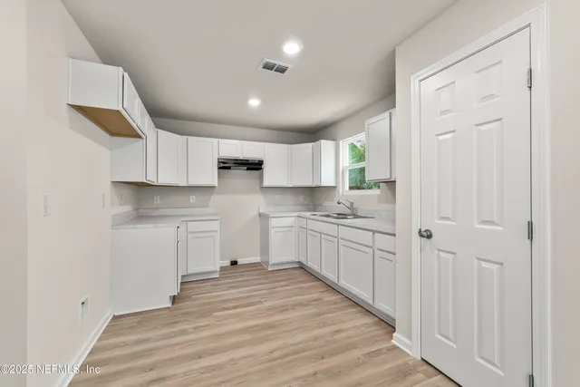 a kitchen with granite countertop white cabinets and white appliances