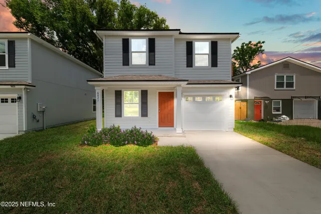 a front view of a house with a yard and garage