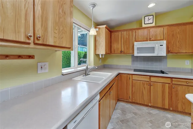 a kitchen with stainless steel appliances granite countertop a sink and a microwave