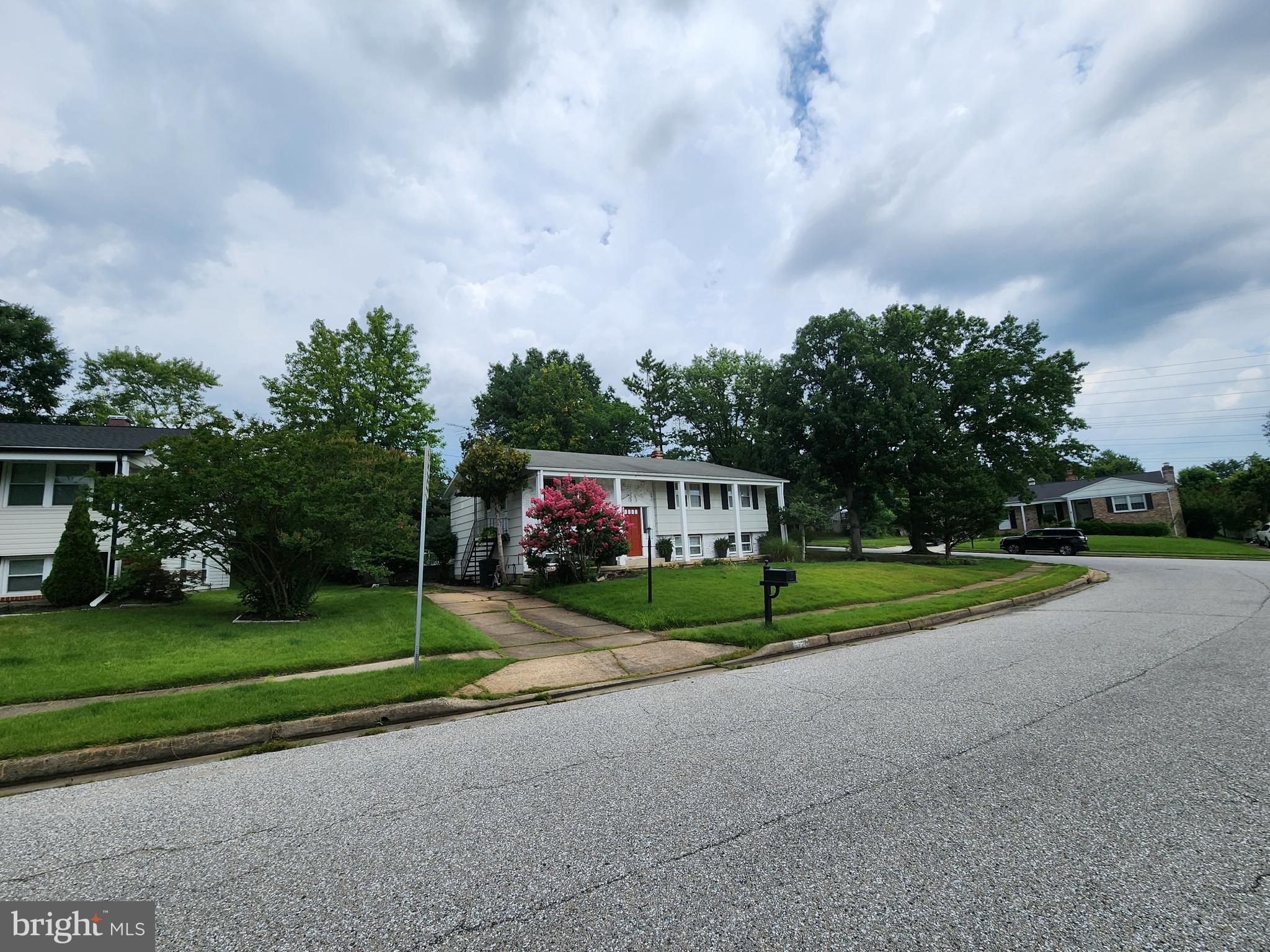 6720 Garvey Road Baltimore, MD 21237 - Photo 4 of 13 a view of a park with large trees and cars parked in front of it