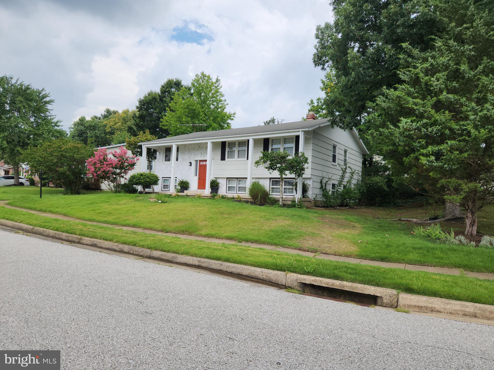 6720 Garvey Road Baltimore, MD 21237 - Photo 6 of 13 a front view of a house with a garden and trees