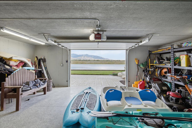 21 Pier Place Tooele, UT 84074 - Photo 90 of 112 Spacious garage featuring a concrete floor, built-in shelving, and direct access to a paved patio area