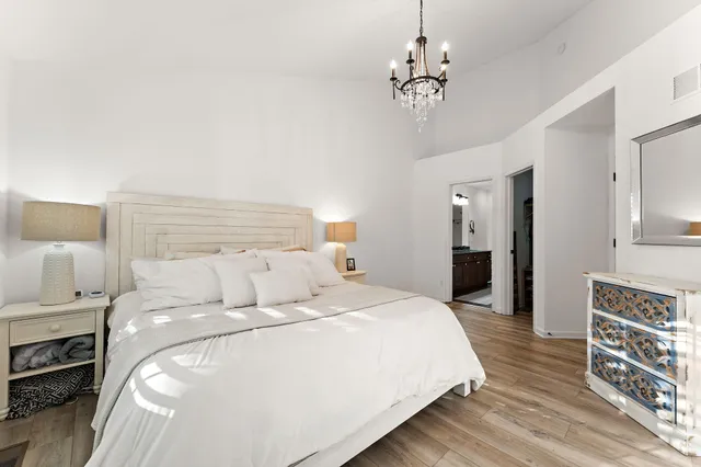 a bedroom with a bed and a chandelier