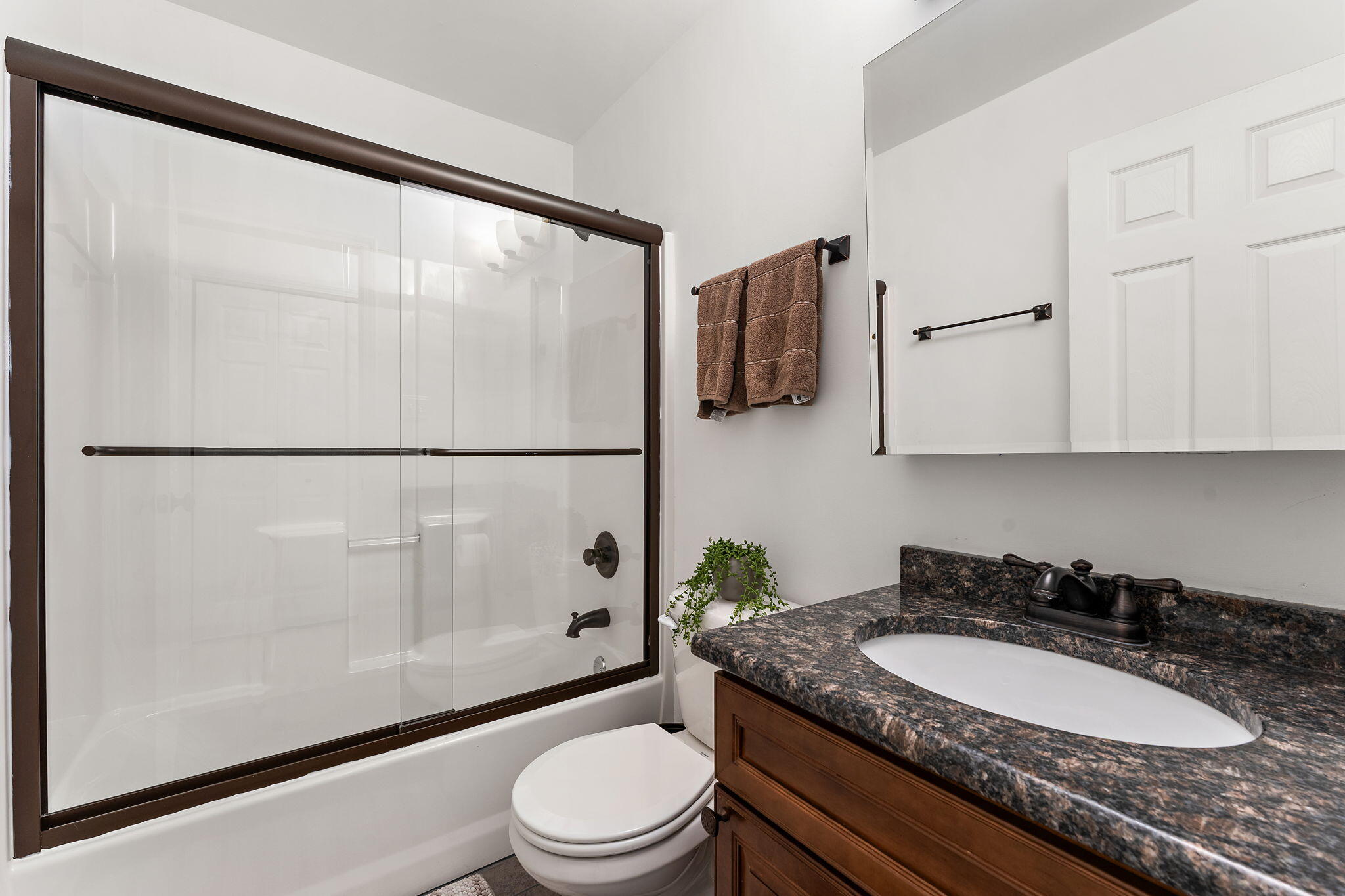 2335 Legend Circle Chesterton, IN 46304 - Photo 20 of 33 a bathroom with a granite countertop sink a toilet a mirror and shower