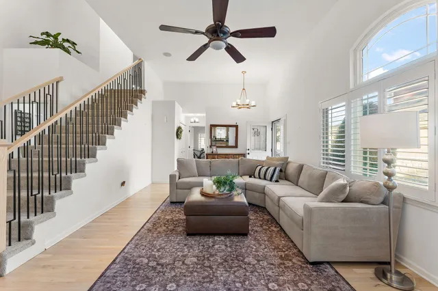 a living room with furniture ceiling fan and a rug