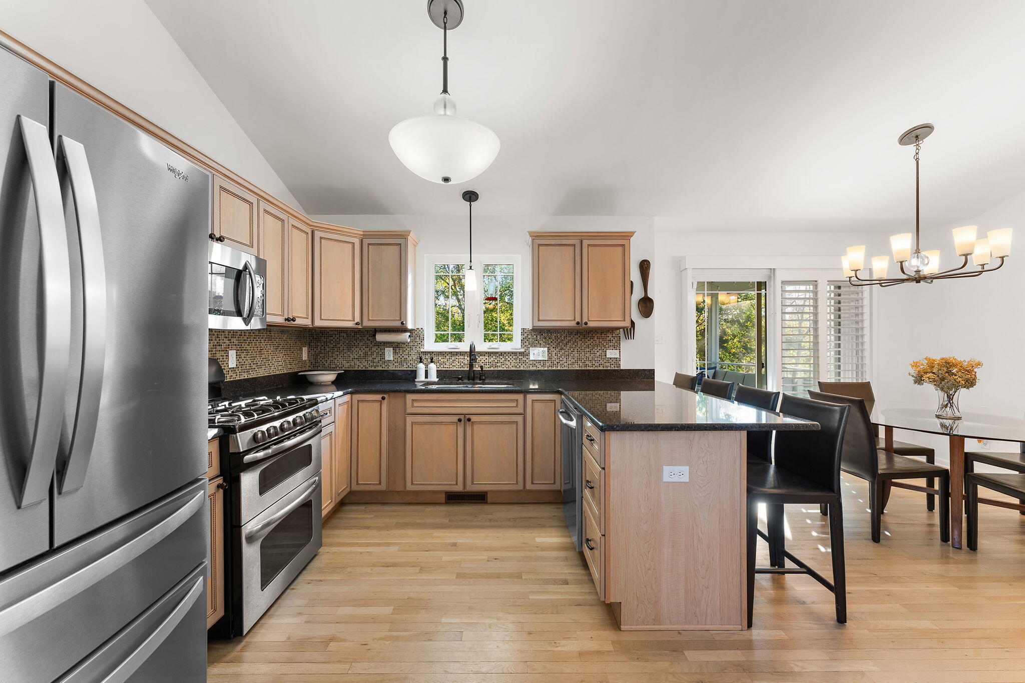2335 Legend Circle Chesterton, IN 46304 - Photo 6 of 33 a kitchen with stainless steel appliances granite countertop a refrigerator a stove a sink a dining table and chairs with wooden floor