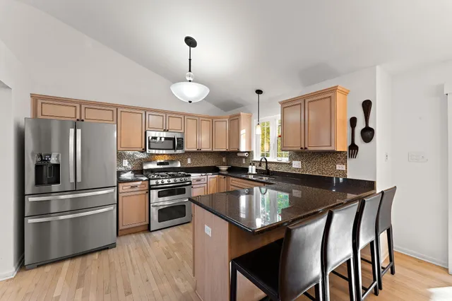a kitchen with kitchen island a large counter top space appliances and cabinets