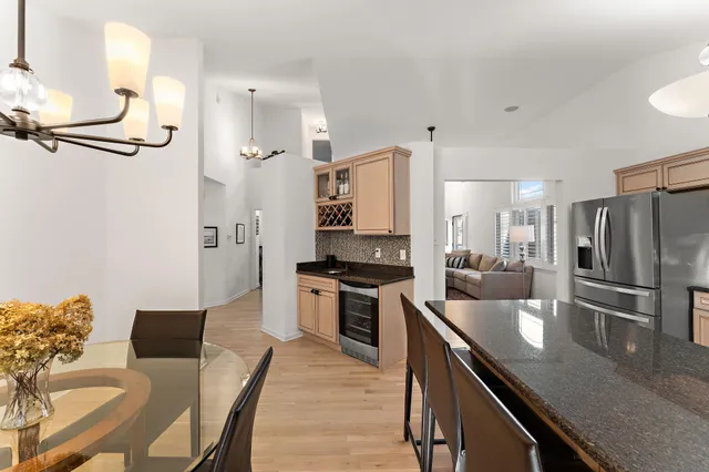 a kitchen with stainless steel appliances granite countertop a stove refrigerator and chairs