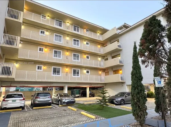 a front view of a building with cars parked