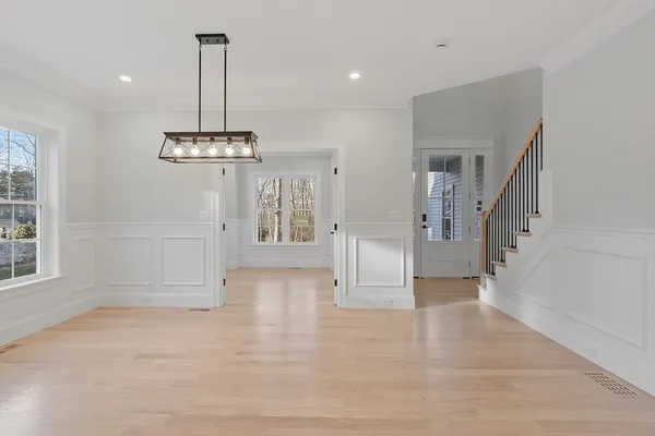 a view of empty room with wooden floor and entryway