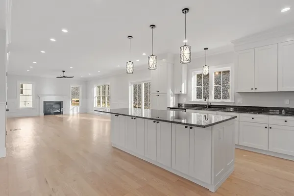a large kitchen with granite countertop a large counter top a sink stainless steel appliances and cabinets