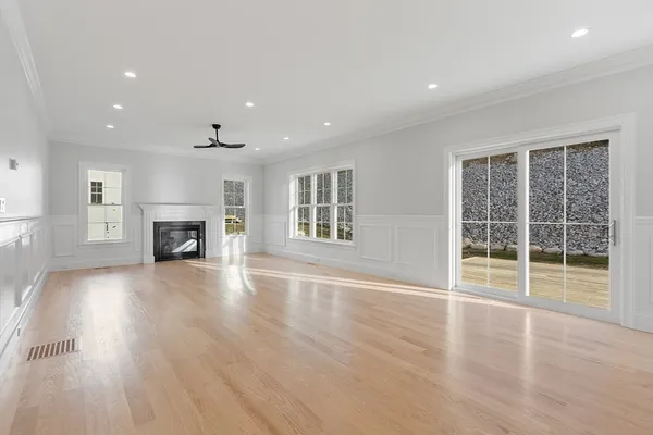 a view of empty room with wooden floor and fireplace