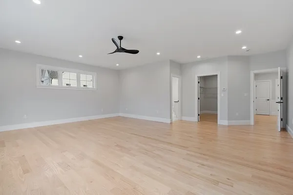 a view of an empty room with a window and a kitchen
