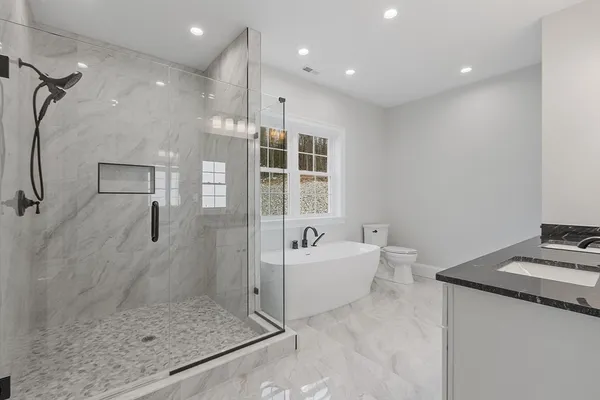 a bathroom with a granite countertop sink mirror and shower