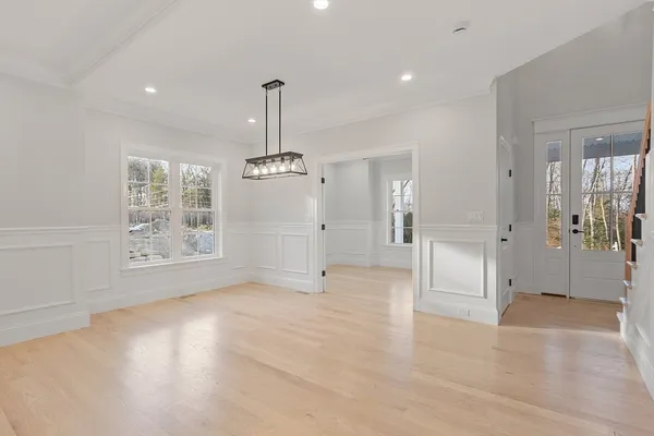 a view of empty room with window and wooden floor