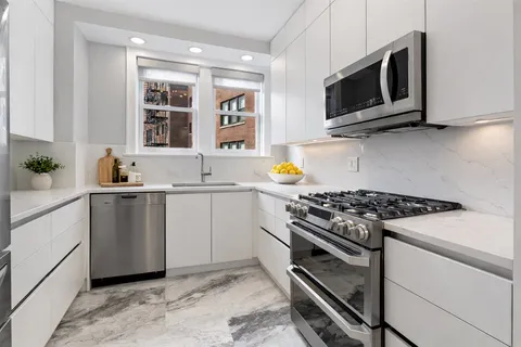 a kitchen with stainless steel appliances a stove microwave and sink