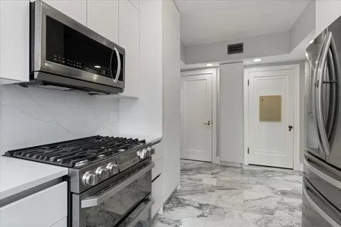 a stove top oven sitting inside of a kitchen