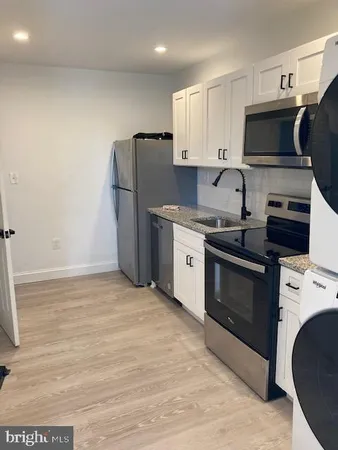 a kitchen with stainless steel appliances a stove a sink and a refrigerator