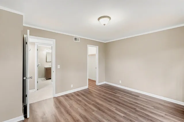 a view of a room with wooden floor and a bathroom