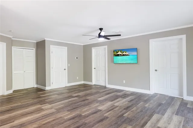 a view of an empty room with window and wooden floor