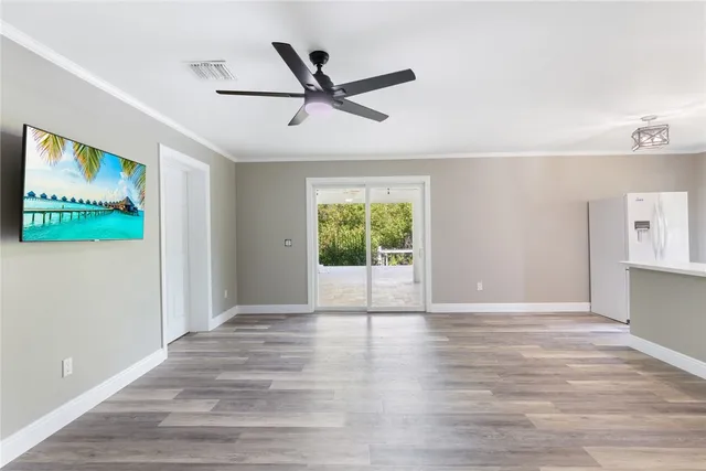 a view of a livingroom with a ceiling fan & hardwood floor