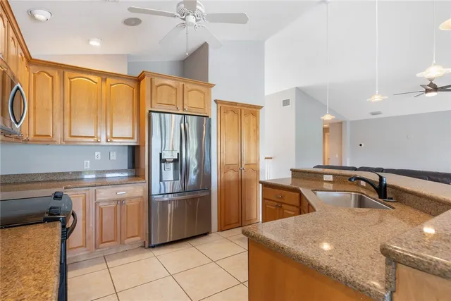 a kitchen with granite countertop a sink stainless steel appliances and cabinets