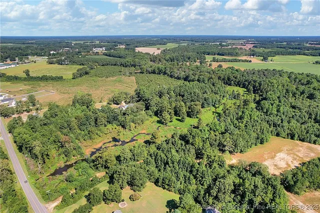 an aerial view of residential houses with outdoor space and river