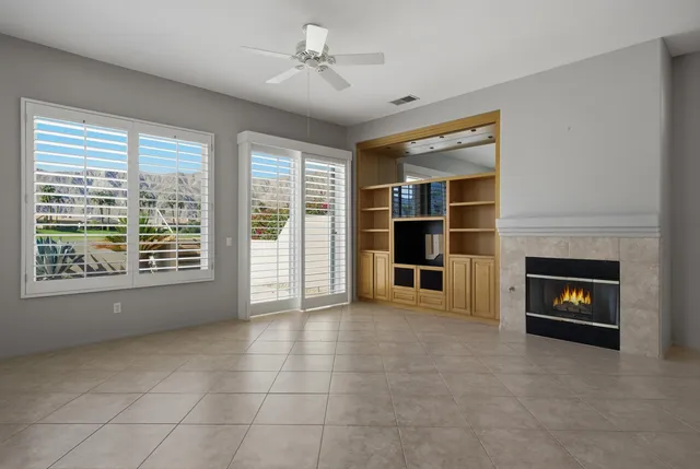 a view of an empty room with a fireplace and a window