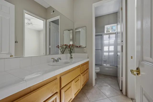 a bathroom with a granite countertop sink a toilet and shower