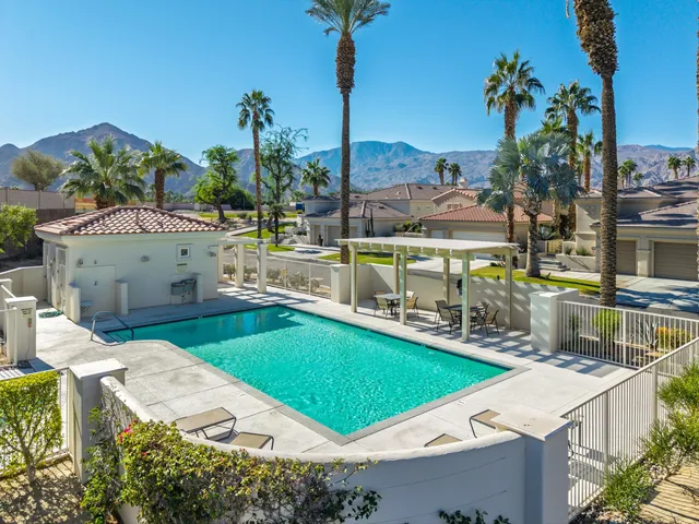 a view of a swimming pool with a patio and a garden