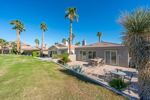 a view of a house with pool and chairs