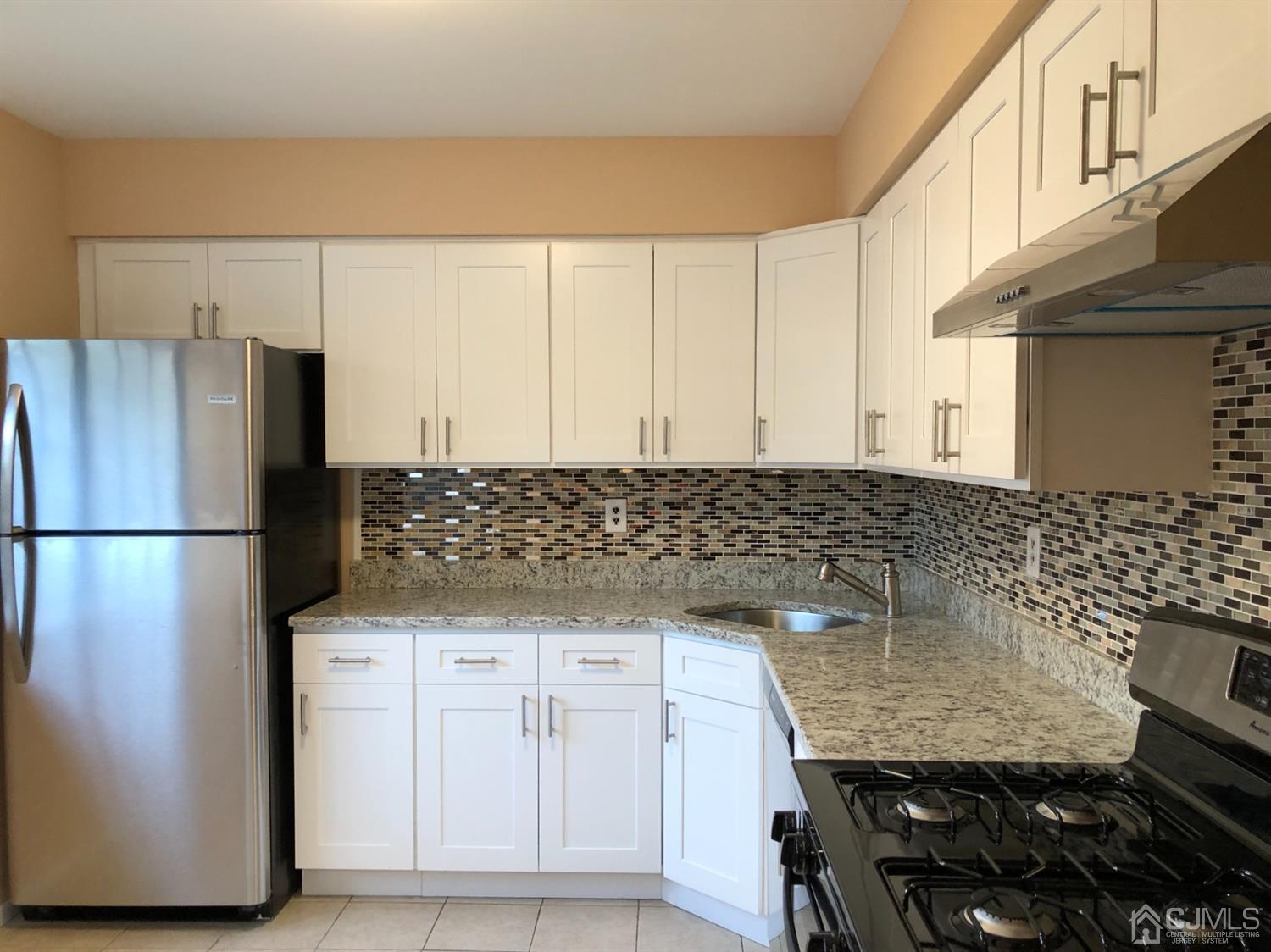 7706 Hana Road Edison, NJ 08817 - Photo 2 of 28 a kitchen with granite countertop a refrigerator and a sink
