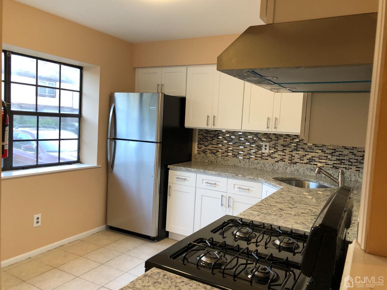 7706 Hana Road Edison, NJ 08817 - Photo 5 of 28 a kitchen with a stove a refrigerator and cabinets
