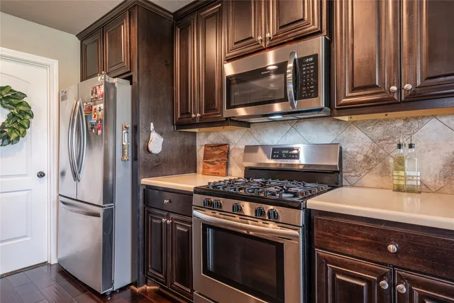 a kitchen with stainless steel appliances granite countertop a stove microwave and refrigerator