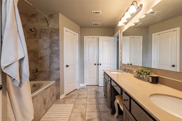 a bathroom with a sink a toilet a mirror and shower