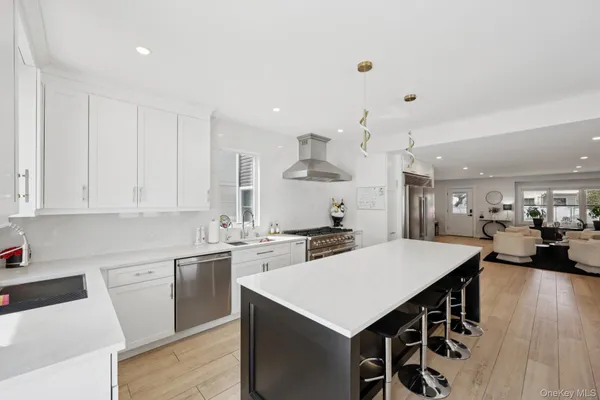 a living room with stainless steel appliances kitchen island granite countertop furniture and wooden floor