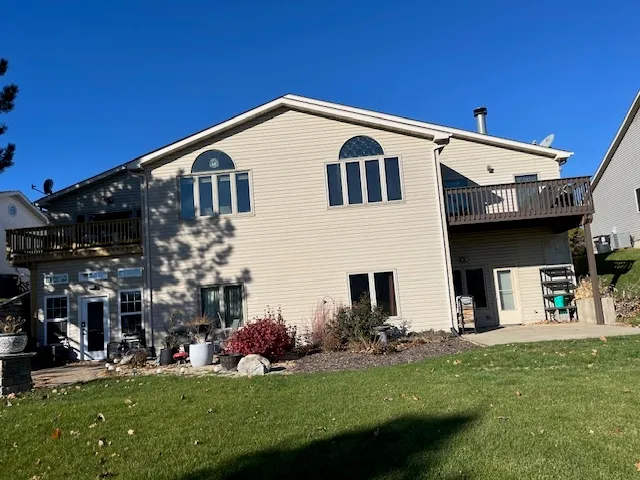 a view of a white house with a big yard and potted plants