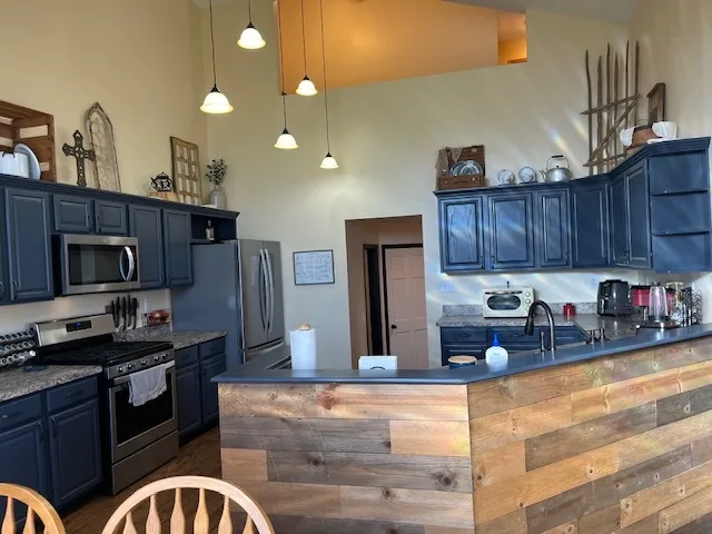 a kitchen with stainless steel appliances granite countertop a stove a sink and a microwave