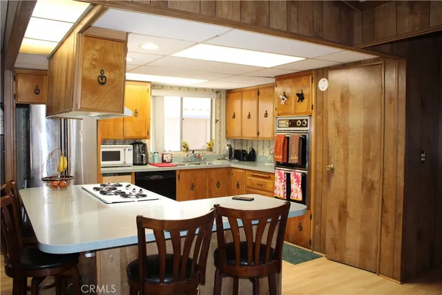 a dining room with stainless steel appliances a table and chairs