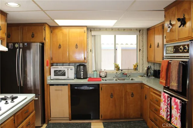 a kitchen with stainless steel appliances a stove refrigerator sink and a microwave