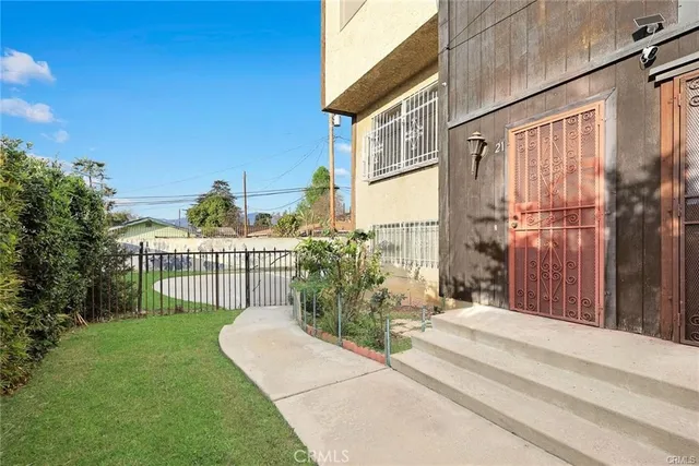 a view of a house with a small yard and wooden fence
